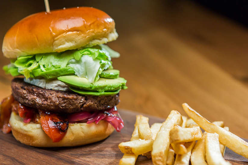 a burger and fries on a wooden board